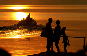 People watch the sunset on Ohrid Lake, Macedonia, June 18, 2005. [© AP Images]