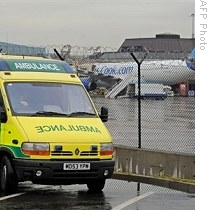 An ambulance is pictured near a Thomas Cook flight from Cancun in Mexico at Manchester Airport, when a passenger reported ill, 28 Apr 2009