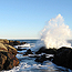 Wave splashes along rocky shore