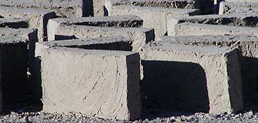 Detail of handmade adobe bricks in sunshine with shadows