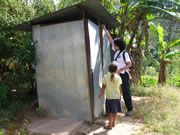 Photo of a specialist checking the latrine in a community