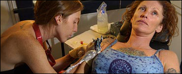 Photo: A woman getting a tattoo.