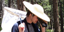 a photo of a butterfly researcher looking through binoculars