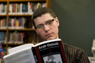 Male reading in the library.