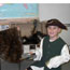 Photo of student with early 1800s period clothing on, next to trunk holding up beaver skin