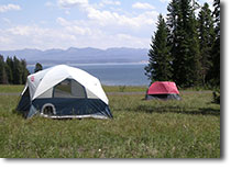 Campground with tents pitched with Yellowstone Lake in the background.