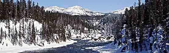 The Yellowstone River flows through a scenic winter landscape.