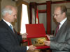 Valeriy Saratov (right), Head of the Sevastopol City Council, presents Dr. Douglas Menarchik, USAID Assistant Administrator for Europe and Eurasia, with a plaque featuring images of local landmarks.