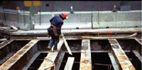 Worker standing on unprotected beams with floor holes