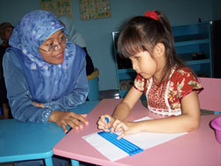 Agustiyawati, left, a specially trained teacher for the blind, uses unique educational tools in Indonesia’s one-of-a-kind facility to help her student, Caca, prepare for entry into her neighborhood school.