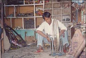 Photo: Kalchu Chaudhary repairs a bicycle at his new shop in Naukhari, Kanchanpur district