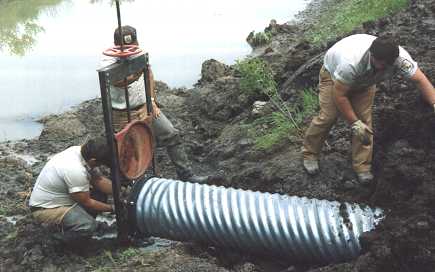 Photo of employees installing a water control structure - Photo credit:  U.S. Fish and Wildlife Service