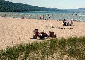 Visitors enjoy a warm summer day at Sand Point Beach on the clear shores of Lake Superior.