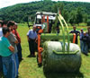 Farmers from Buzim watch as a member of the Jezerski Farmers Association demonstrates the use of the association's new baler