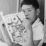 Manzanar internee boy reading a comic book.