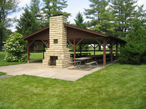 Wooden picnic shelter with a brick fire pit.