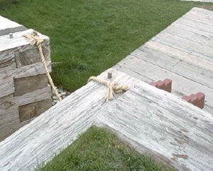 on top of a wood and earth wall topped with grass, you can glance into the fort.