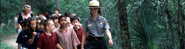 School group walking on a trail with a ranger.