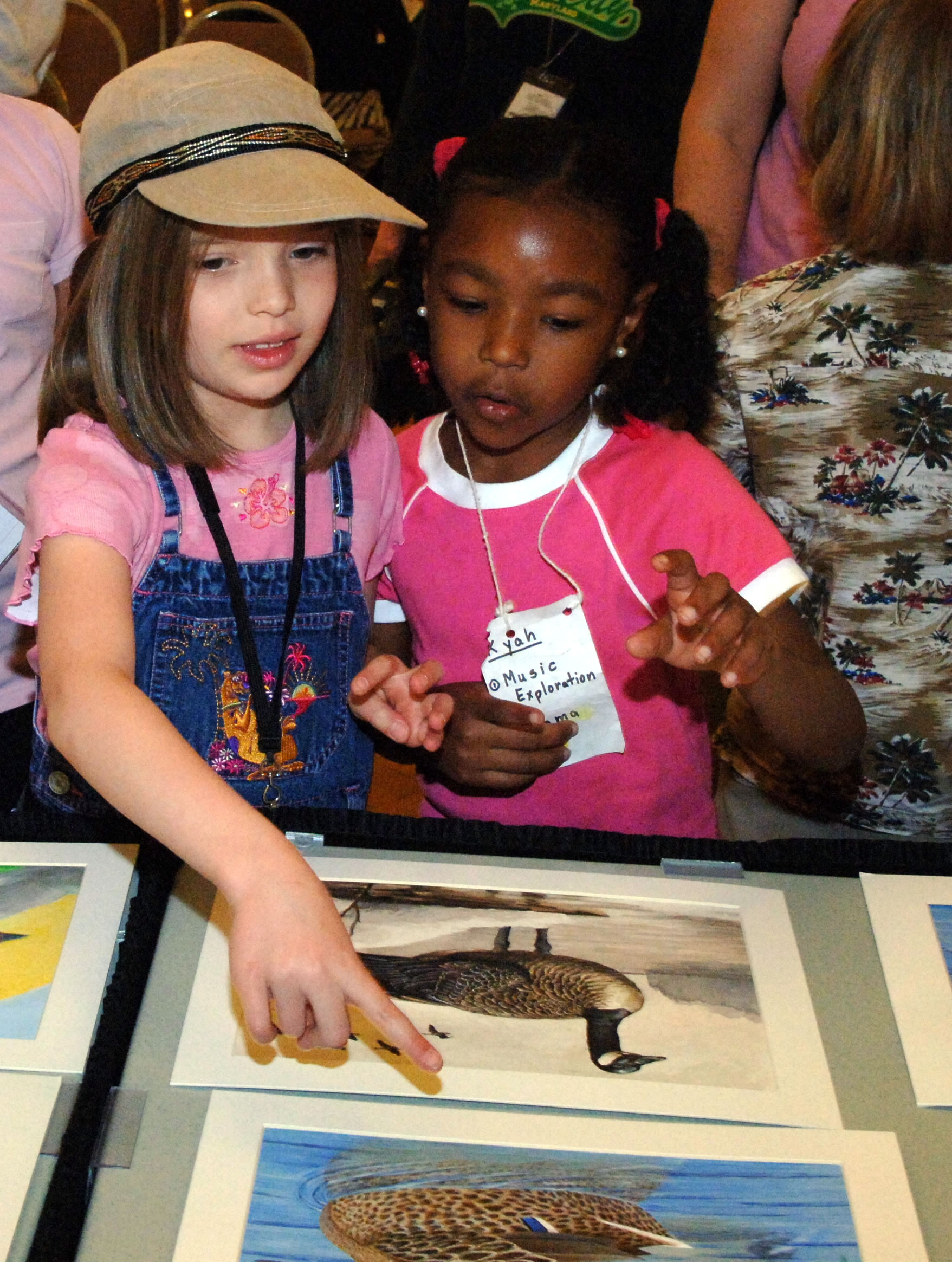 Students view artwork at a Junior Duck Stamp Contest.