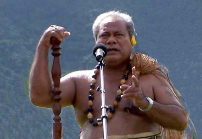 A Samoan story teller with staff and whisk.