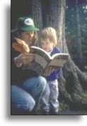 Environmental Education teacher reading to child in a forest setting