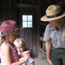 Girl with a junior ranger hat speaks with a park ranger.