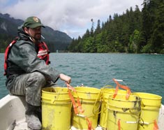 Park employee with buckets of silt collected behind the dams