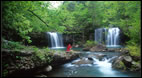 A waterfall image with a person sitting nearby.