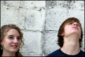 girl and boy against cinder block wall