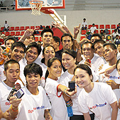 Photo of Erik taking photos with the local kids while they clamor for a  picture with him