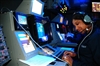 Petty Officer 3rd Class Wendy Rambo identifies air contacts and issues queries to unknown aircraft.