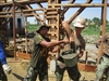 U.S. Navy Seabees and Indonesian marine corps engineers transfer concrete.