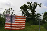 New Orleans, LA - An American flag hangs on a chain link fence in the Lower 9th Ward / Desire St. Community (New Orleans, LA).  More than 35,000 national service participants contributed more than 1.6 million hours of volunteer service during the first year of hurricane relief and recovery efforts along the Gulf Coast, according to a report released on August 25, 2006 by the Corporation for National and Community Service.