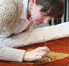 Aimee Ducey, conservation program intern from New York University, removing accretion from the sacred Hawaiian cloak.