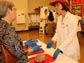 Photo of Alexis Webb, in brain hat and in front of an actual brain, answering a visitor's question.