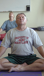 Participants in a yoga class meditating while in the lotus pose.