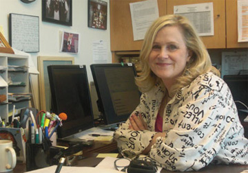 NIDA Communications Director, Carol Krause, sitting at her desk