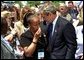 President George W. Bush embraces a woman at the 21st Annual Peace Officers Association Memorial Service at the United States Capitol Wednesday, May 15. "When an officer dies in the line of duty, an entire community will pause in sorrow and in admiration with the depth of feeling Americans reserve for people who protect us every day," said the President in his remarks to the families of fallen peace officers.  