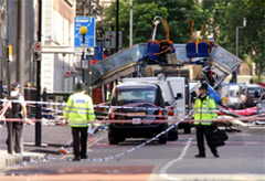 Police officers stand in front of a sealed off area around a bus in London after the July 7, 2005 terrorist attacks. (AFP Photo/Carl de Souza)