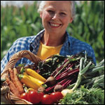 Photo: A woman holding a basket of fresh vegetables