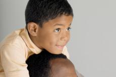 Photograph of a young boy on his father's shoulders