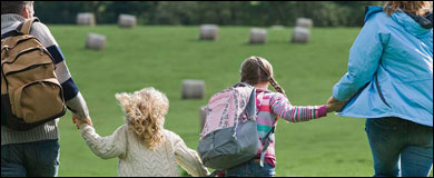 Photo: A family holding hands and walking outdoors