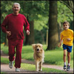 Photo: Father, son and dog running in a park.