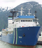 OSV Bold in port with snow-capped mountains in the background