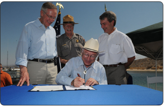 At Cottonwood Cove on Lake Mead National Recreation Area, Secretary Salazar signs the document to approve more than $135 million for restoration and improvements through the Southern Nevada Public Lands Management Act (SNPLMA).  Left to right are Senator Harry Reid, Lake Mead NRA Superintendent Bill Dickinson, and BLM Director Bob Abbey.  (photo credit: Tami A. Heilemann-DOI)