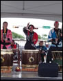 photo of Martha and Bob Boyko (in blue hapi coats) lead members of Austin Taiko in a performance at the Pecan Street Festival