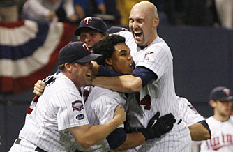 Twins players mob Alexi Casilla, center, after he drove in the winning run in the bottom of the 12th inning against the Tigers.