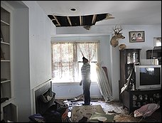 William Maldonado, 25, surveys the fire damage to the living room of the Arlington County house he shares with 15 family members.