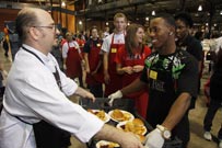 Dean Liesenfelt, cooking school manager at the Plano Central Market, hands a tray of turkey dinners to UNT Dallas student Kirby Tate at the Feast of Sharing at Fair Park in Dallas Nov. 10.