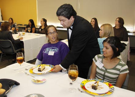 Federico Vizcarra of Cadillac Cantina serves dessert to University of North Texas at Dallas students Crystal Saenz (l) and Magali Tirado Oct. 2. The university offered students a formal dinner as part of a business etiquette class.